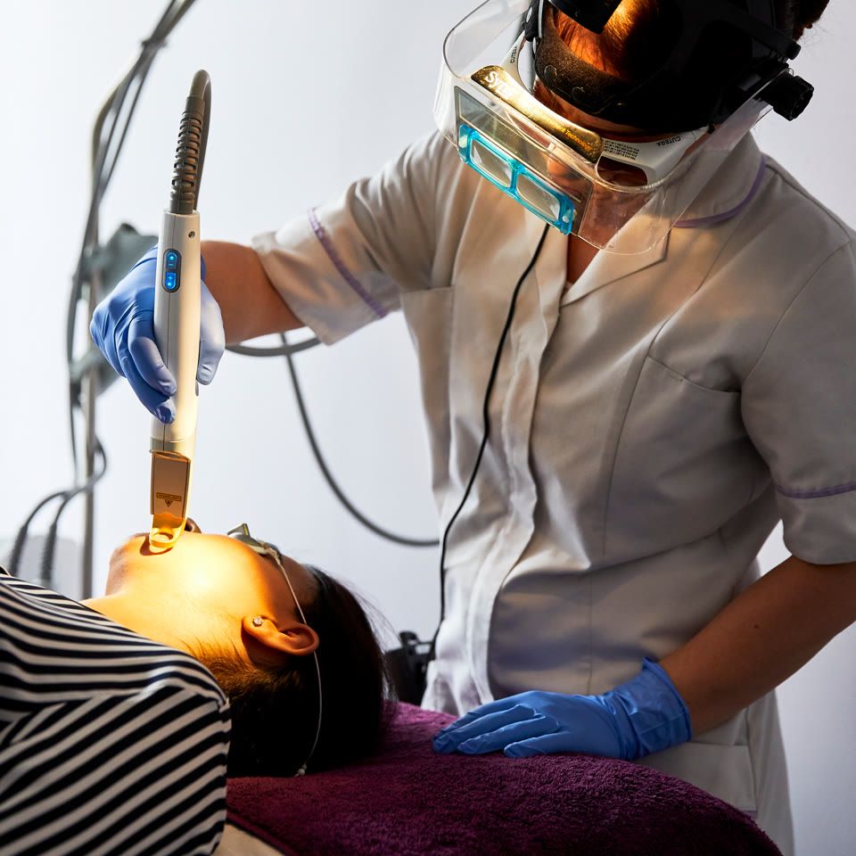 Clinician performing Fractora skin resurfacing treatment on a patient's forehead using a handheld device in a clinic